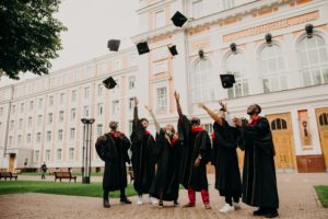 college graduates throwing their caps